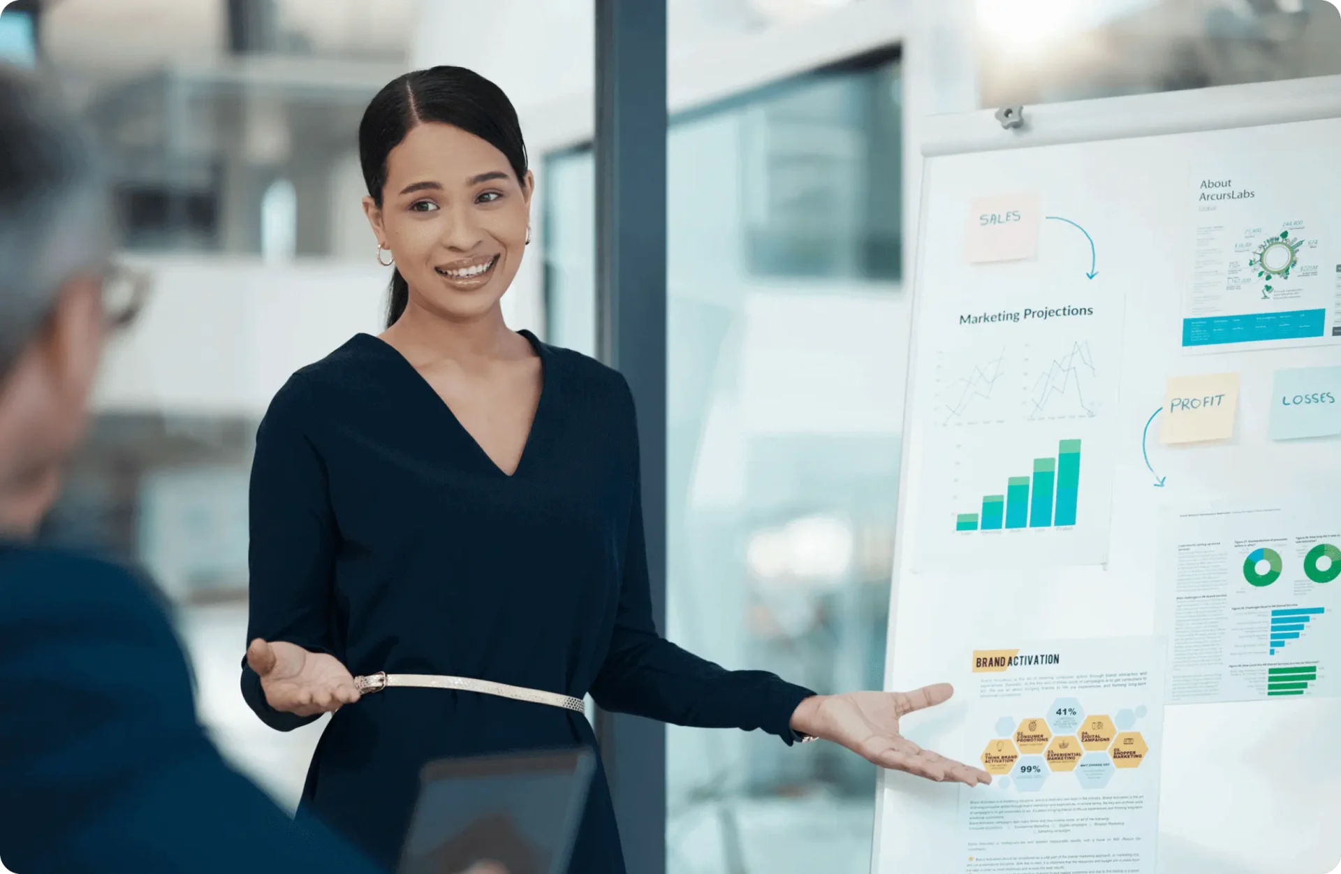 Smiling presenter beside marketing projections board